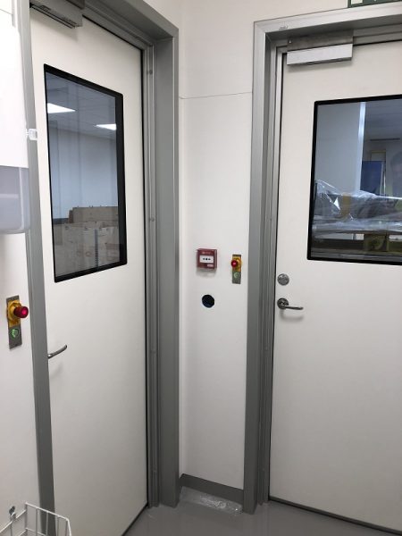 Kontrollterminal med magnet inbyggd i handtaget och dörrstängare över dörren
